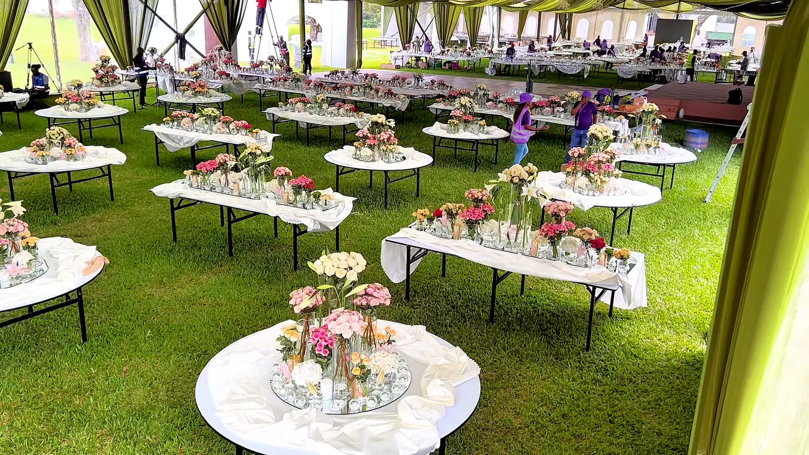 Finished arrangements laid out on the lawn before they go to the tables