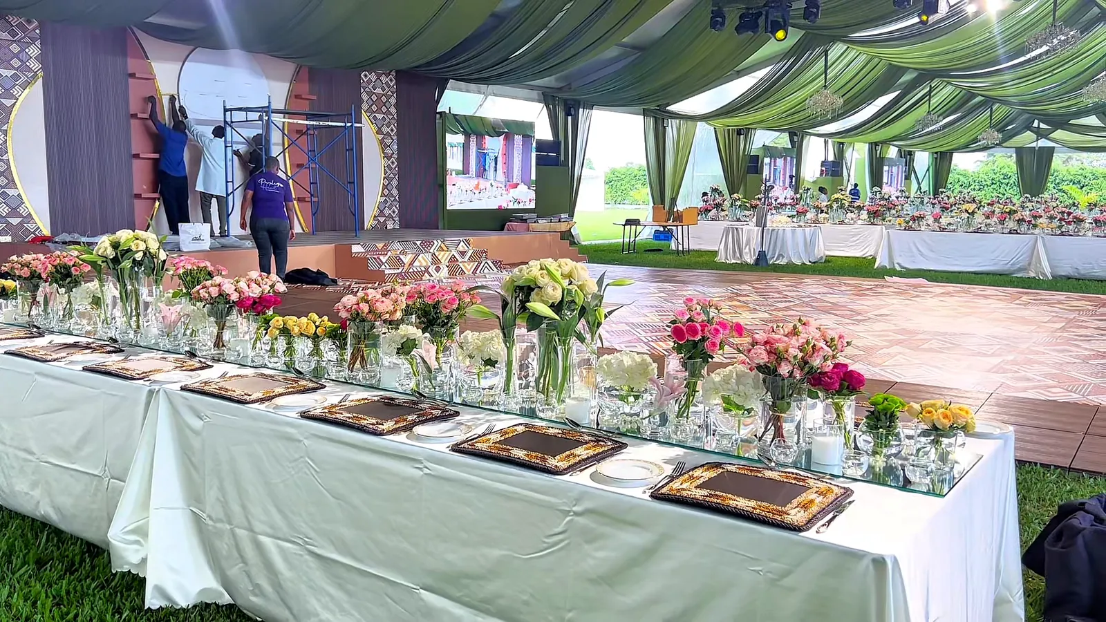 A long guest table lined with roses, lilies and chrysanthemums