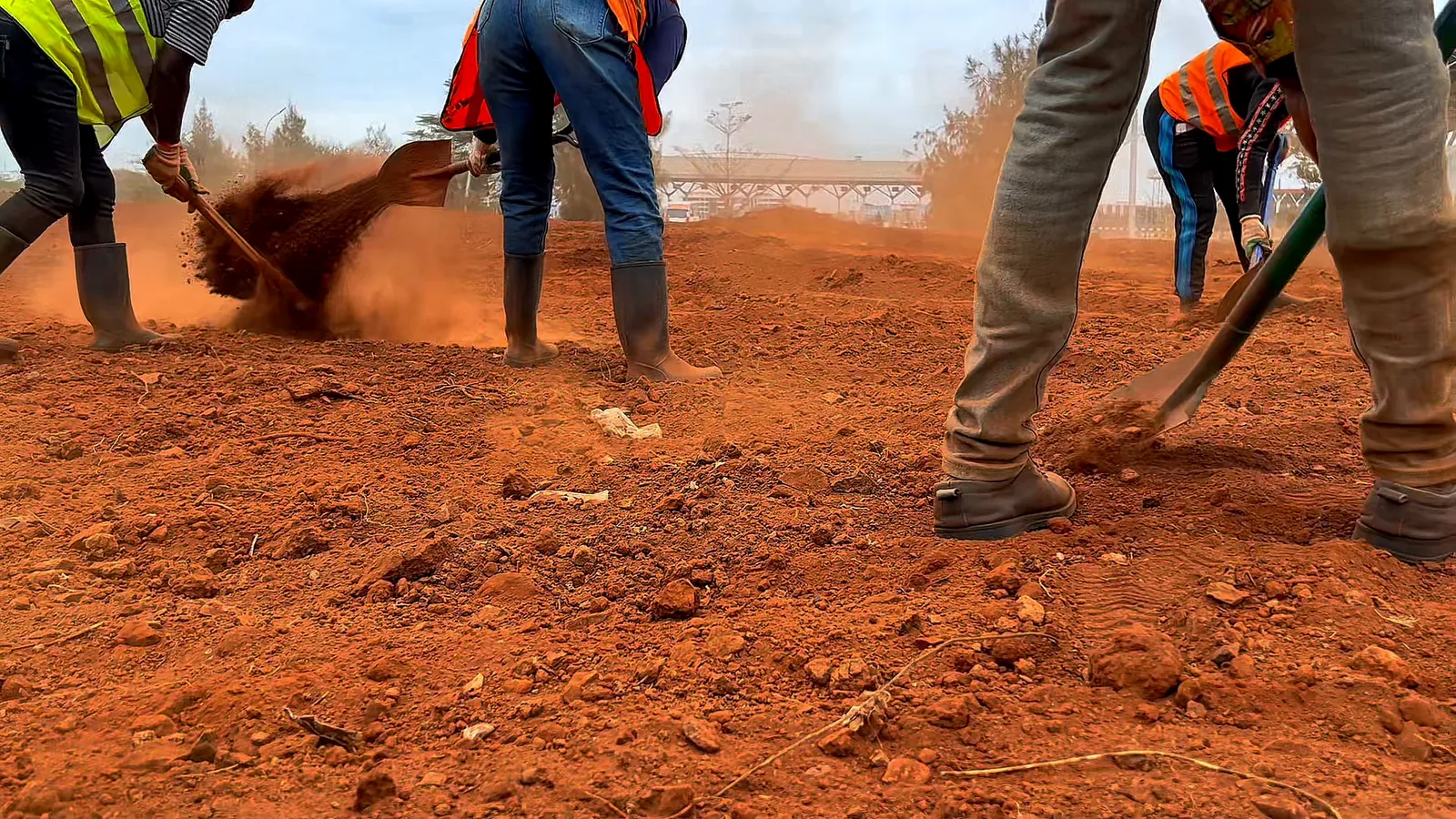 The team raking and levelling the red soil