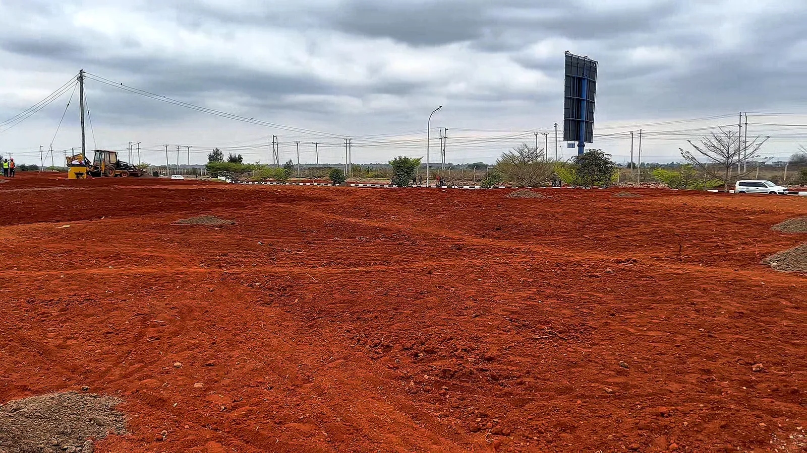 The wide prepared site with the airport road beyond