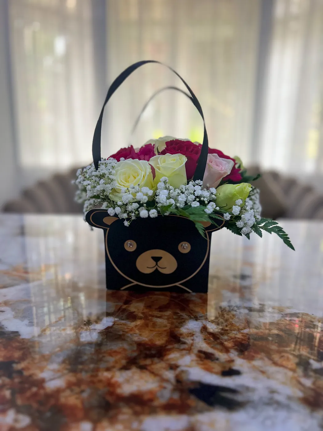 A bear-faced gift bag of roses and gypsophila